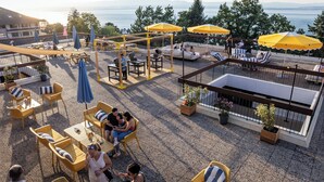 Une terrasse extérieure avec des sièges, des parasols et une vue sur la mer.