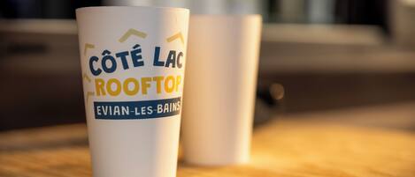 Two white mugs with text on them, placed on a wooden surface.