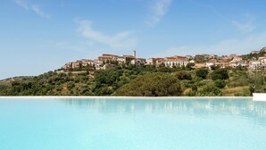 Un hôtel situé sur la côte, doté d’une grande piscine, de bâtiments construits à flanc de colline et d’une tour imposante.