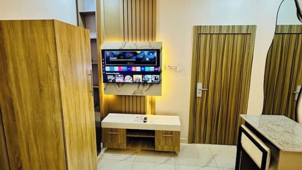 A modern bathroom with a vanity, a built-in TV, and wooden paneling. - Studio(S5)@LEKKI PHASE 1, 24/7 Pwr by NgoZiLiving

 (Lekki)