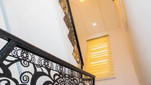 A staircase with ornate black railings and a ceiling light. - Studio(S5)@LEKKI PHASE 1, 24/7 Pwr by NgoZiLiving

 (Lekki)