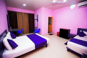 A hotel room with two beds, a desk, a chair, a TV, and a ceiling fan. - Bevary Guest (Anuradhapura)