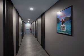 A hallway with a poster of a beach scene and QR code. - Aspira Escape Ao Nang Krabi (Krabi)