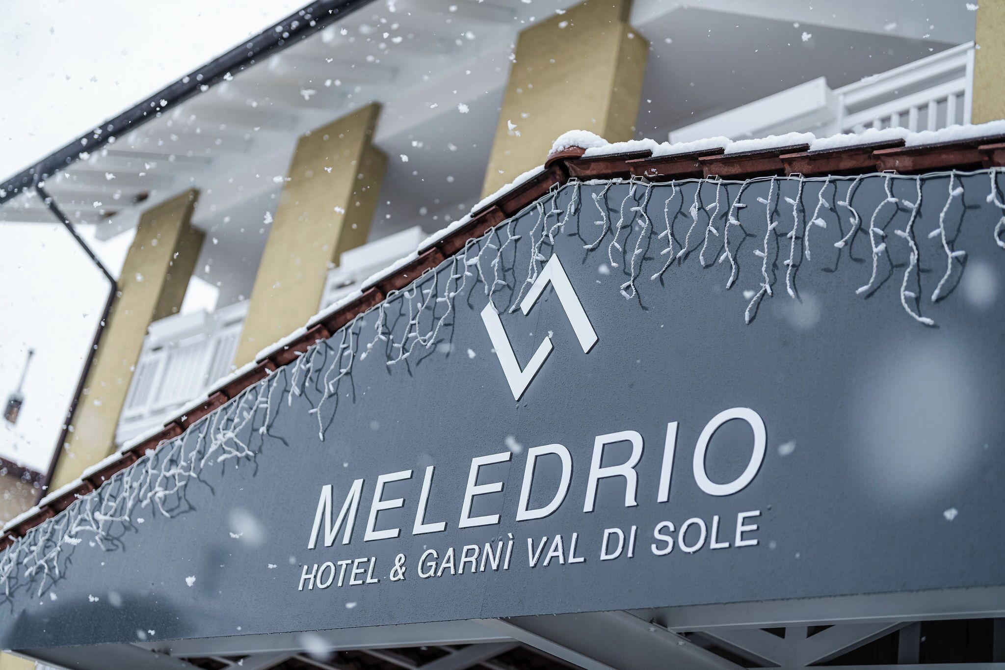 Une enseigne d’hôtel portant le nom « MELEDRIO HOTEL & GARNI VAL DI SOLE ».