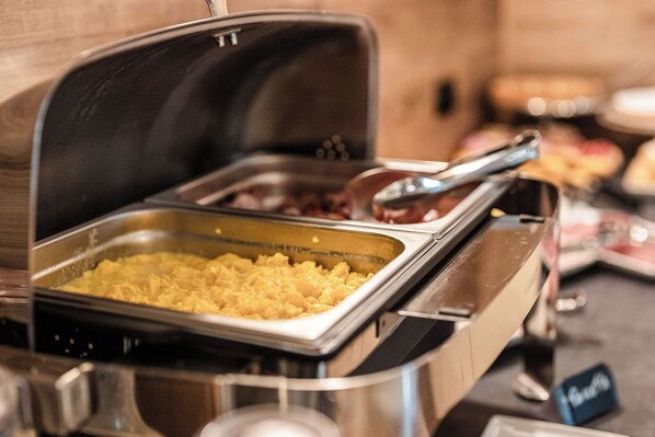 A buffet setup with a variety of food items, including scrambled eggs and other dishes. - Hotel Garni Meledrio (Dimaro Folgarida)