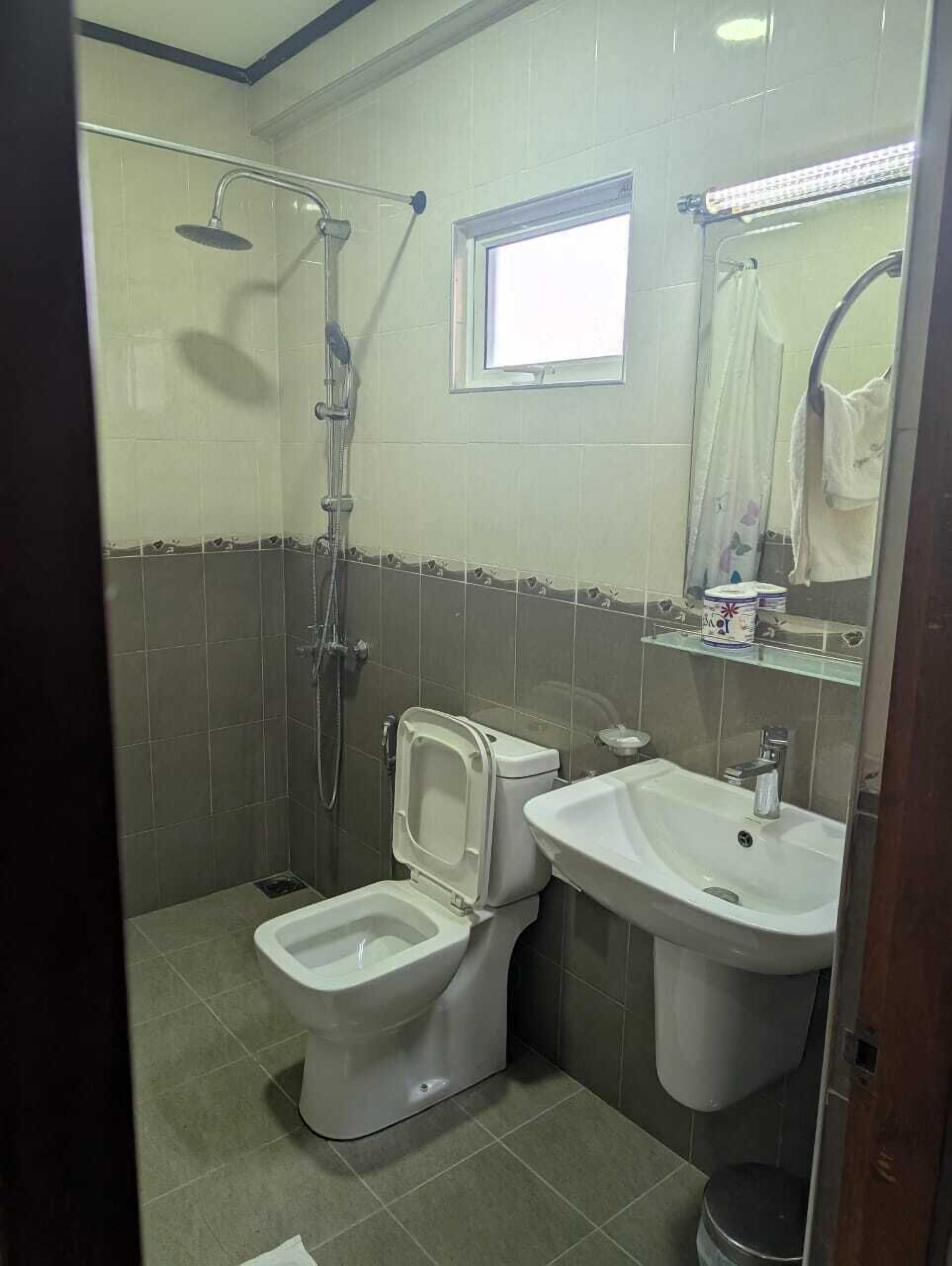 A bathroom with a toilet, bidet, sink, and shower.