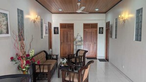 A spacious living area with a wooden ceiling, a dining table with chairs, and a sofa. - GG Lodge (Mirissa)