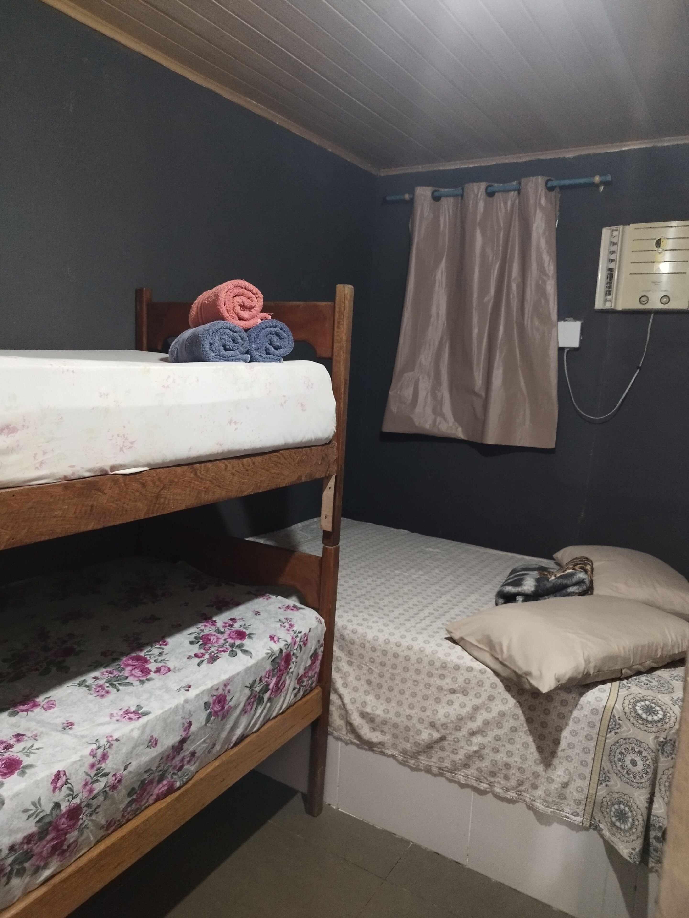 Ein Etagenbett mit Blumenmuster-Bettwäsche und ein kleiner Nachttisch mit Lampe.