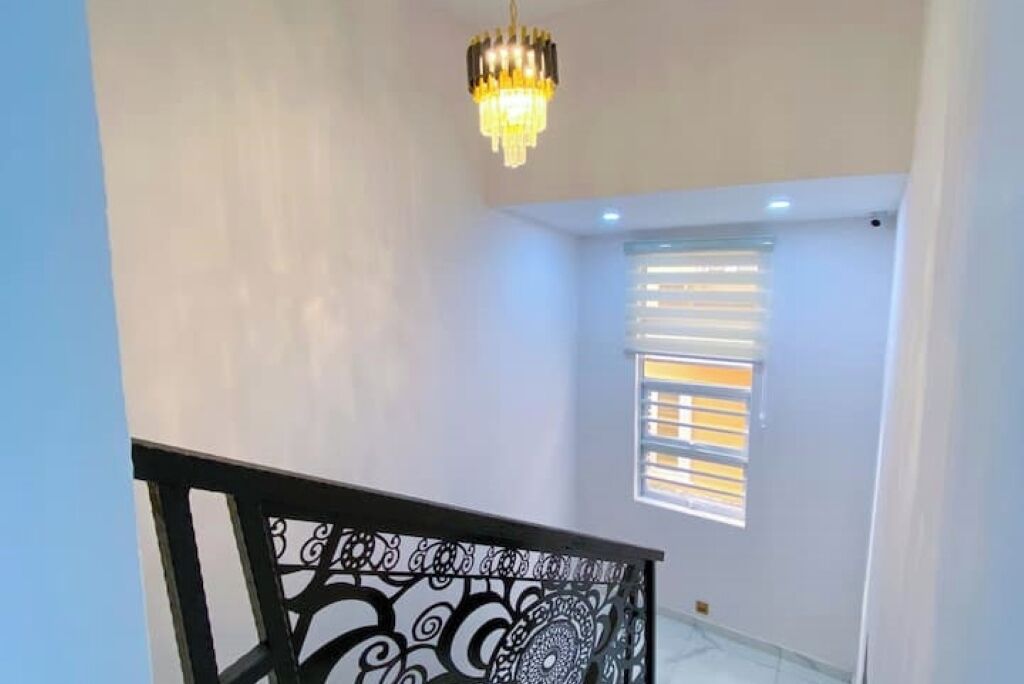 A staircase with a black railing and a chandelier.