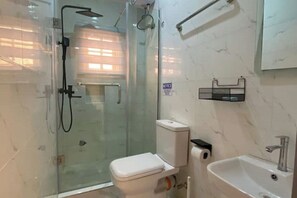 A bathroom with a glass-enclosed shower, a white toilet, a sink, and a towel rack. - Studio(S2)@LEKKI PHASE 1, 24/7 Pwr by NgoZiLiving

 (Lekki)