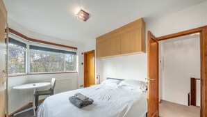 Une chambre à coucher avec un lit, un bureau et une fenêtre.