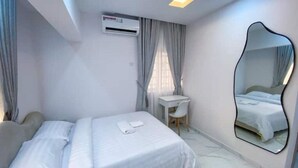 A hotel room with a bed, a desk, a chair, an air conditioning unit, and a mirror. - 1Bed&Parlour(B4)@Lekki PH 1.24/7 Pwr By NgoZiLivin

 (Lekki)