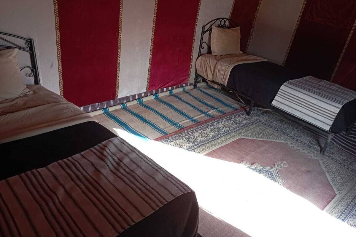 Una habitación con dos camas, un sofá y un tapete estampado.