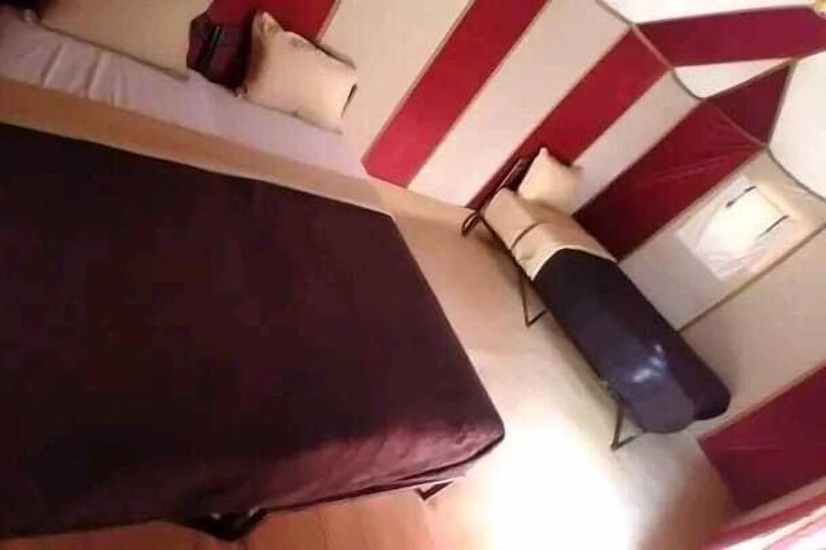 Una habitación con una cama, una silla y una mesita.