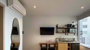 A compact kitchen with a built-in TV, a small dining area, and a refrigerator. - w* | Tranquil Loft w/ Great Terrace in Bocagrande (Cartagena de Indias)