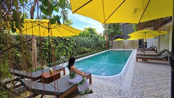 Piscina a l'aire lliure, para-sols i gandules