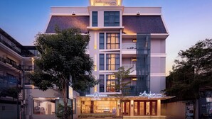 A modern hotel with a prominent sign, multiple floors, and a well-lit entrance. - Angkor Mansion & Residence (Siem Reap)