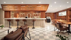 A modern bar area with a checkered floor, wooden bar counter, and seating arrangements. - Angkor Mansion & Residence (Siem Reap)