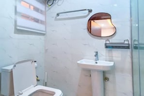 Ein Badezimmer mit Toilette, Waschbecken und Spiegel.