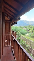 Un balcón de madera con vista a un paisaje montañoso.
