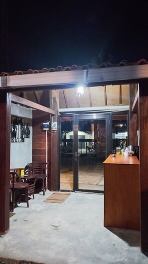 A wooden structure with a bar area, a seating arrangement, and a sign indicating a nearby parking area. - Sandyakala Borobudur (Borobudur)