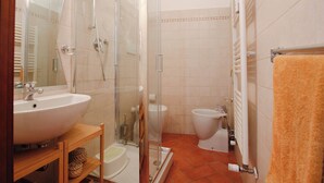 A bathroom with a glass-enclosed shower, a sink, a toilet, and a towel rack. - Pratovecchio Suite (Florence)