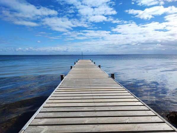 A wooden pier extending into calm waters under a partly cloudy sky. - 5 Star Holiday Home in Sydals (Sydals)