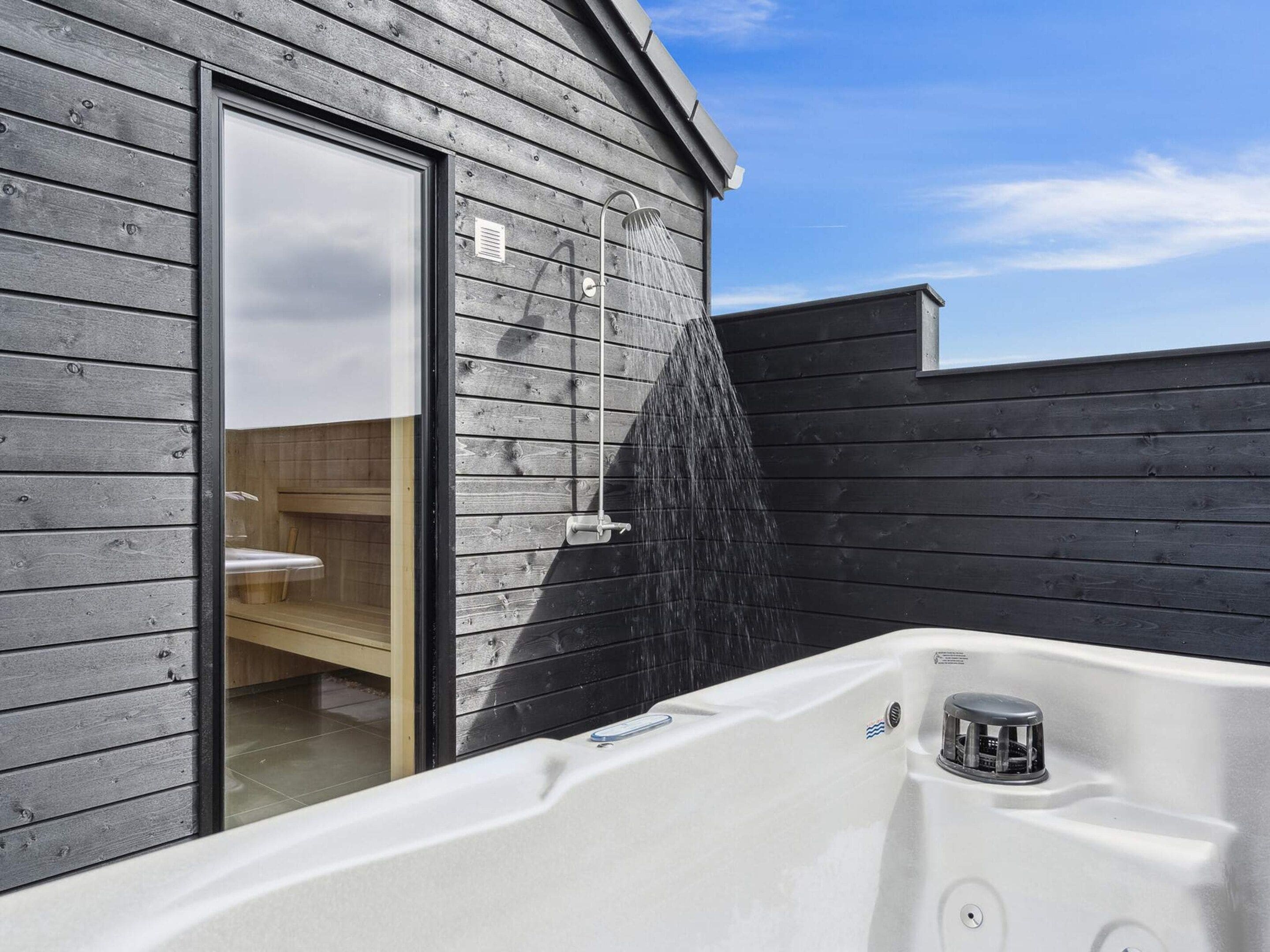 A spa area with a hot tub, a wooden wall, and a window.