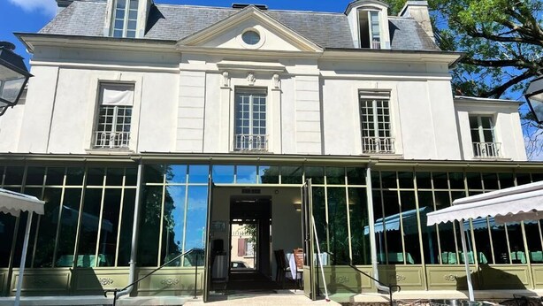 A large, two-story building with a symmetrical facade, large windows, and a covered outdoor seating area. - IL MAESTRO - HOTEL RESTAURANT DU CHATEAU (Ecouen)