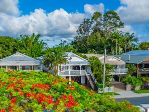 A coastal hotel with multiple-story buildings, a balcony, and lush greenery.