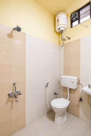 Une salle de bain avec douche, toilettes et lavabo.
