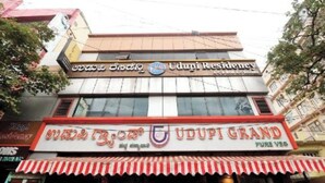 Un edificio con letreros que indican Udupi Residency y Udupi Grand.