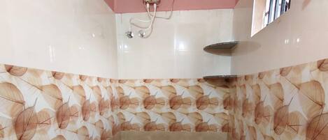 A bathroom with a toilet, a shower, and a water heater.