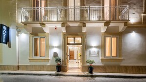 A hotel facade with a double balcony, large windows, and a welcoming entrance. - C4 Retreats Gozo (Xaghra)