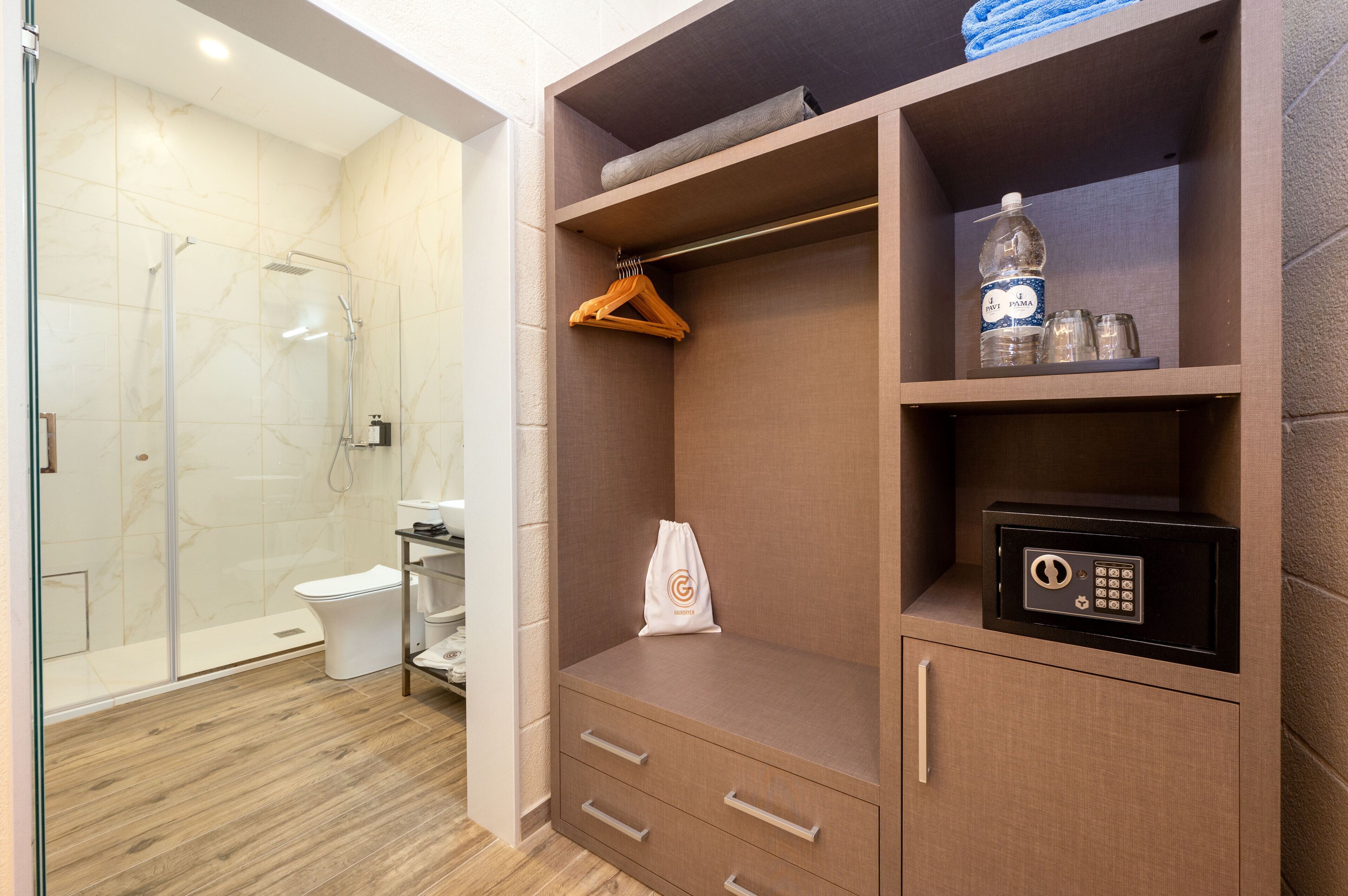 A modern bathroom with a walk-in shower, a toilet, and a wooden floor.