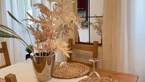 A dining table with a metal vase and two woven placemats. - AURELIA Residence (Roma)