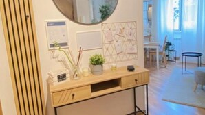 A modern room with a wooden console table, a round mirror, and wall-mounted decorations. - AURELIA Residence (Roma)