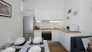A modern kitchen with white cabinets, a built-in oven, and a microwave on the countertop. - Casa Giotto (Scandicci)