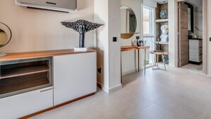 A modern interior with a TV mounted on the wall, a wooden console table, and a mirror.