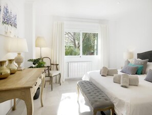 Relax in a serene bedroom with a large bed, tufted headboard, and plush pillows.
