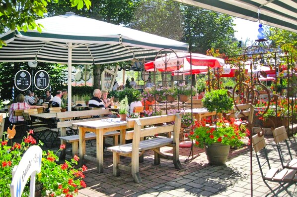 Enjoy outdoor dining with a variety of seating options and lush greenery.