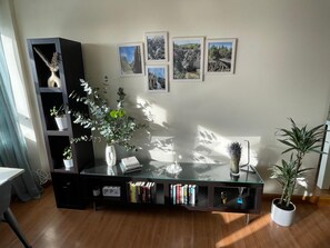 Cozy living space with a glass coffee table, book collection, and framed photographs.