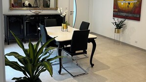 Un espace repas moderne avec une table et des chaises, un grand miroir et un tableau accroché au mur.