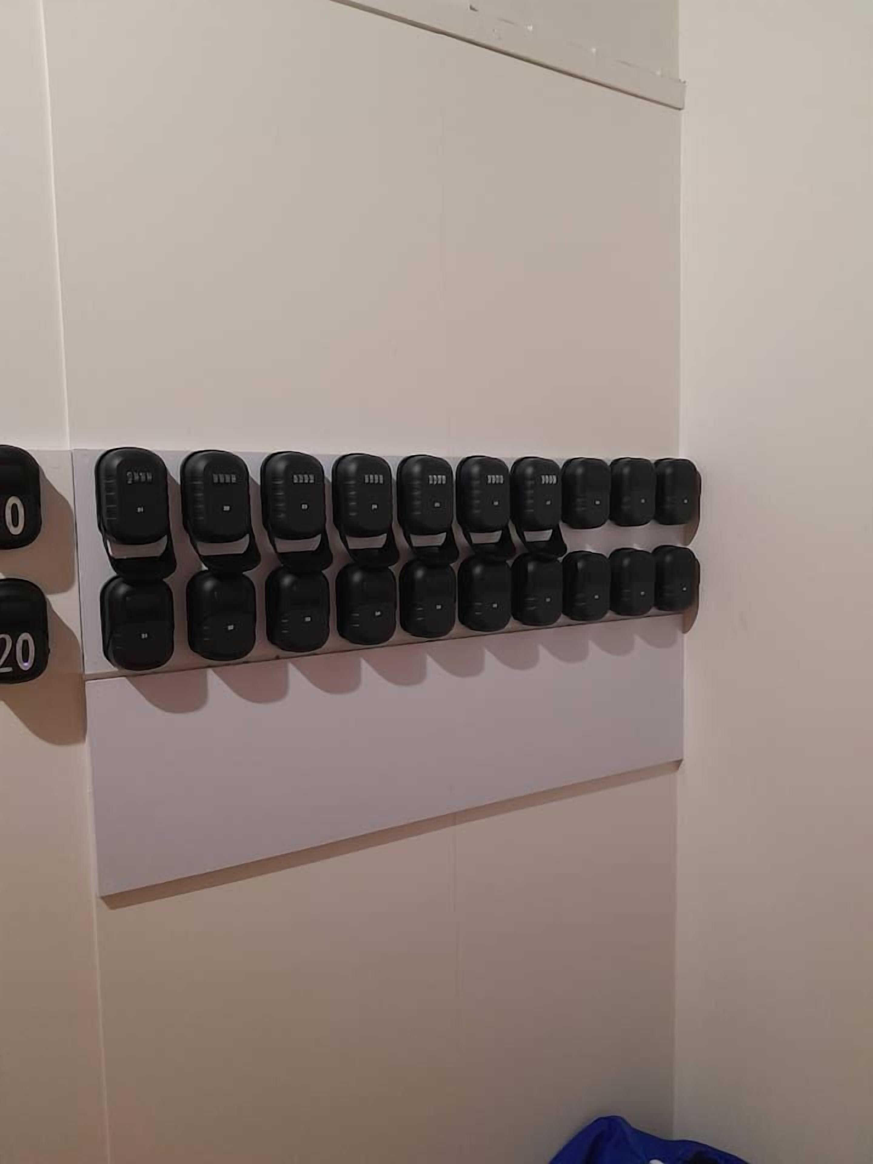 Eine Reihe schwarzer Knöpfe an einer Wand, jeweils mit einer Zahl darüber.