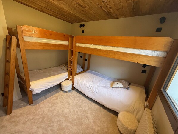 A bunk bed room with two beds, a small rug, and a window. - 2-bedroom apartment with balcony, parking and Wi-Fi in La Clusaz (La Clusaz)