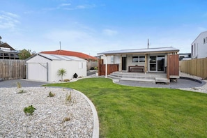 A residential property with a well-maintained lawn, a covered patio, and a garage.