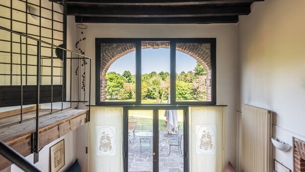 A staircase leading to a balcony with a view of a garden.
