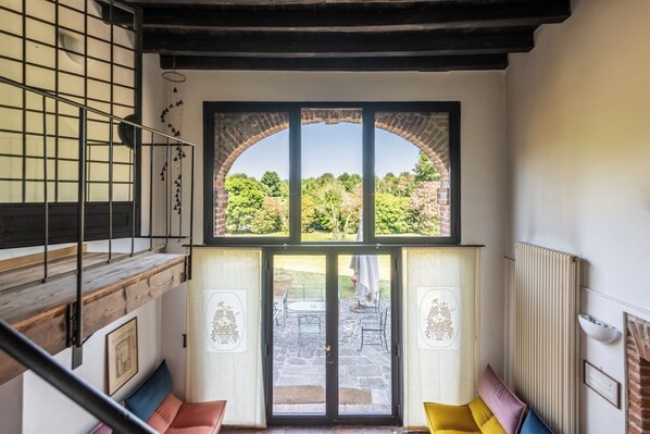 Una escalera conduce a un balcón con vistas a un jardín.