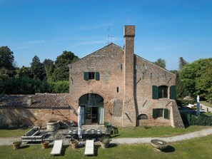 A brick building with a chimney, a door, and a window.