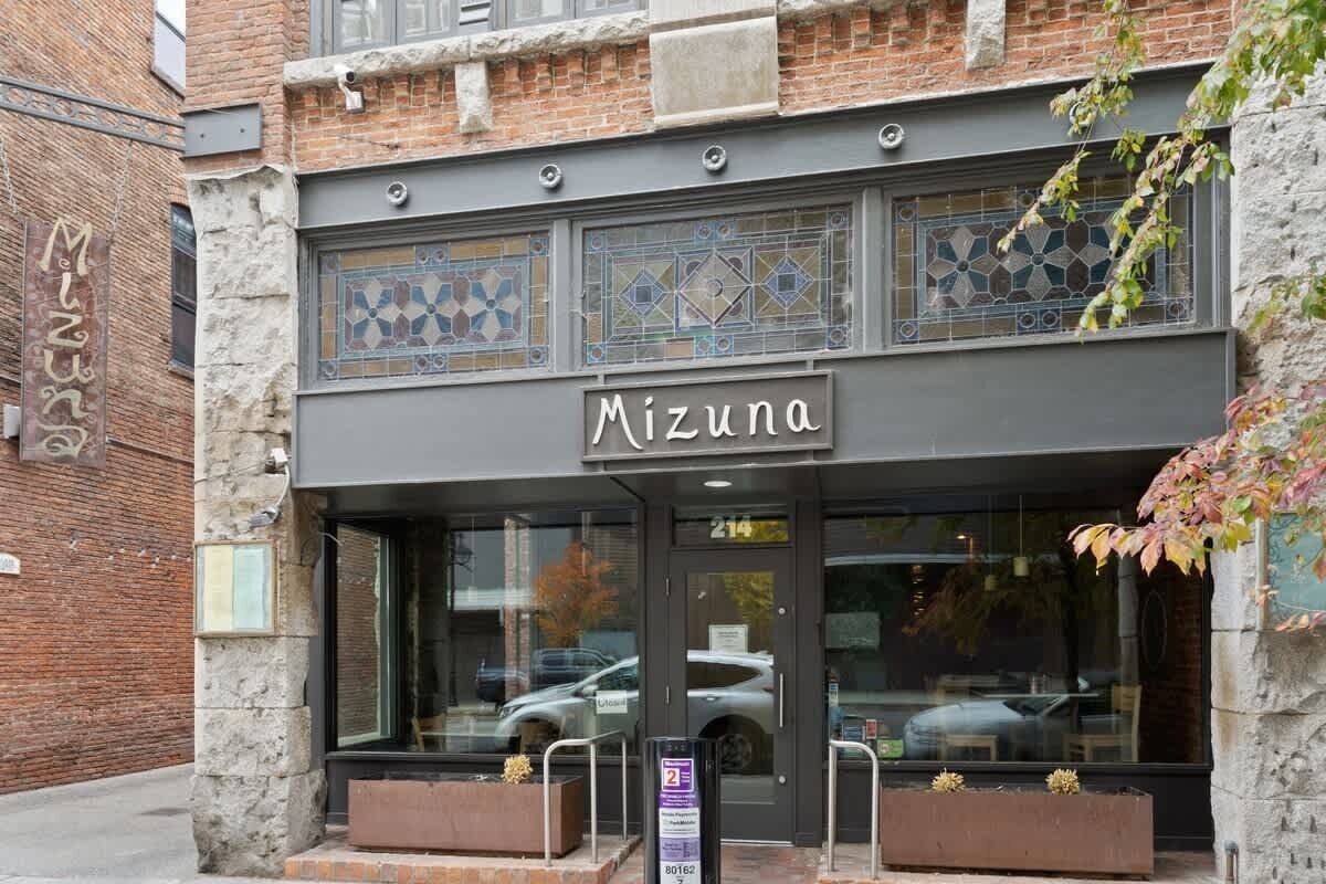 A building with a sign reading "Mizuna" and a glass storefront.